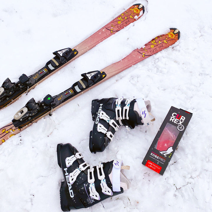 Skis, black ski boots, and CURREX EDGEPRO low profile red insoles sitting in the snow #1-wahle-dein-profil_low