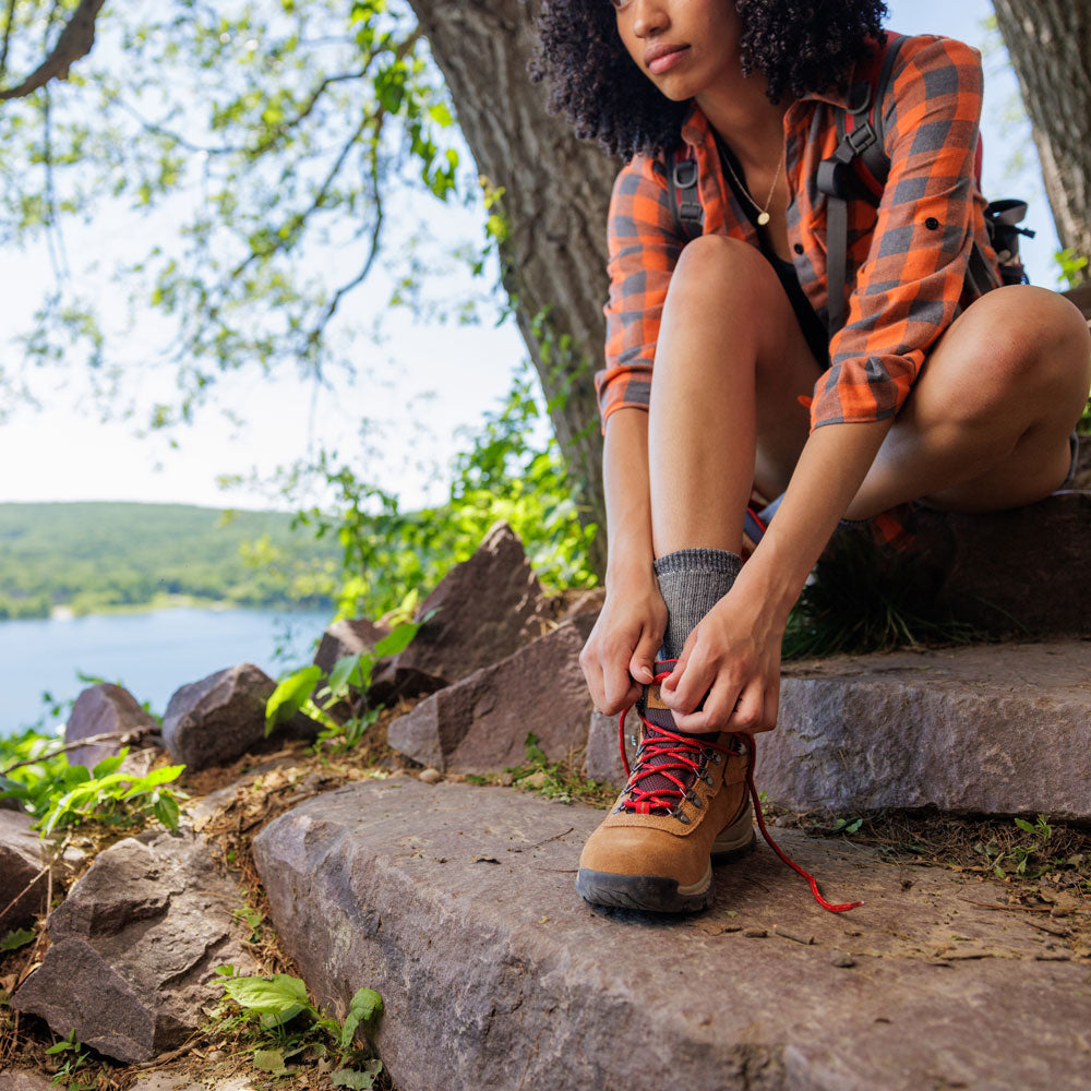 Woman taking a break from hiking to tie hiking shoe #1-wahle-dein-profil_med